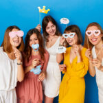 A group of happy females models, celebrated gender reveals envent, isolated blue background.